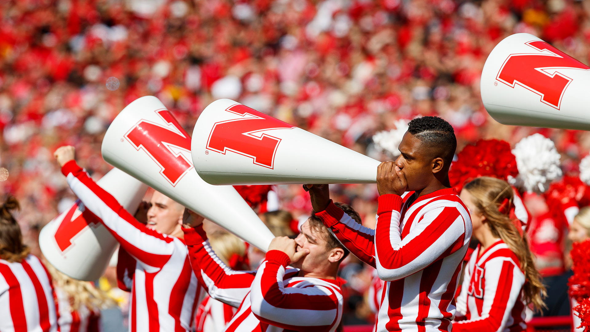 The male cheerleaders use their megaphones to rally the crowd