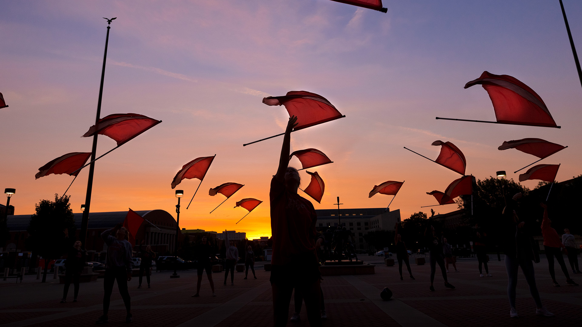 Cornhusker Marching Band Color Guard practices by dawn’s early light outside east stadium