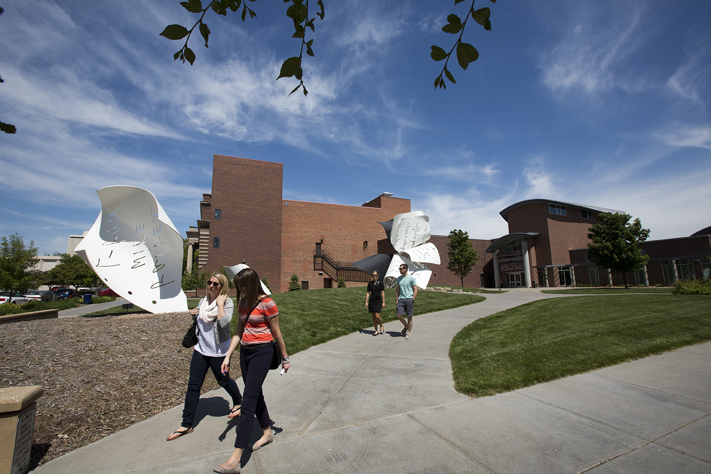 People walking past the paper sculpture 